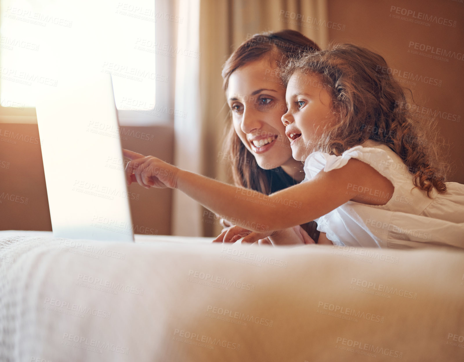 Buy stock photo Shot of a mother and her little daughter using a laptop together at home