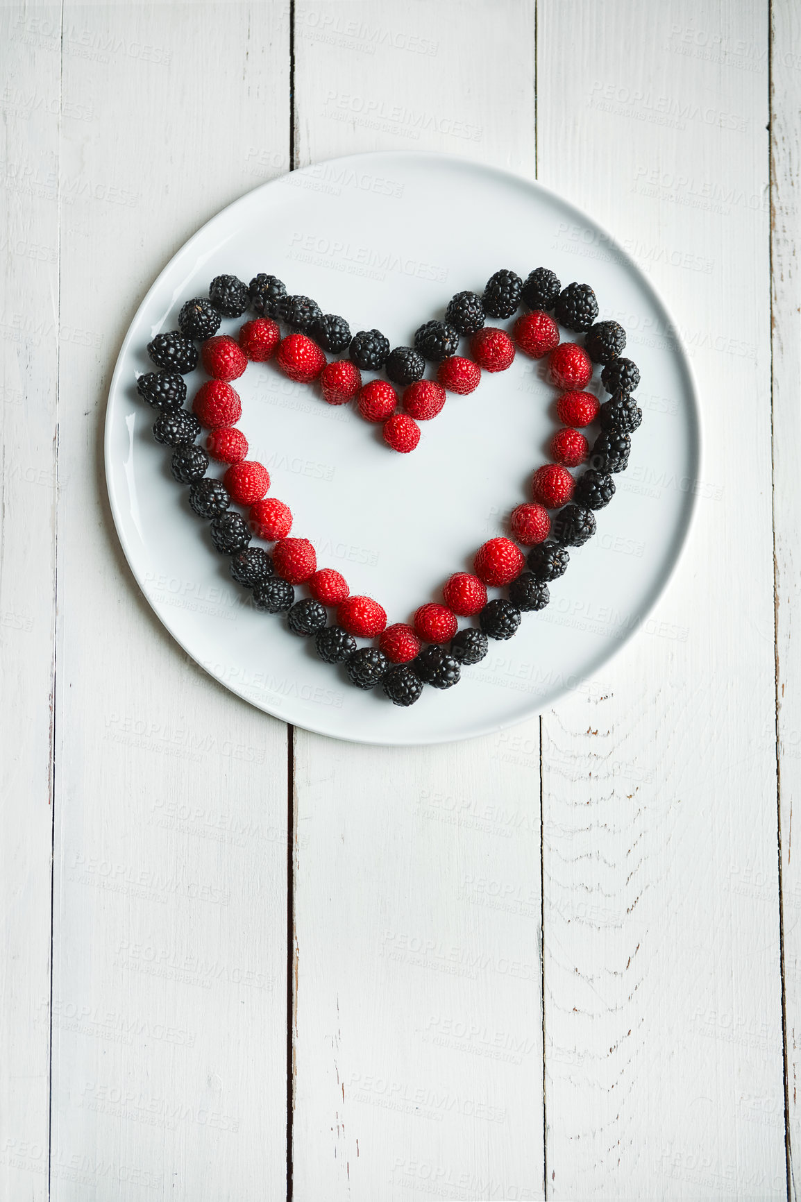 Buy stock photo High angle shot of berries in the shape of a heart on a plate