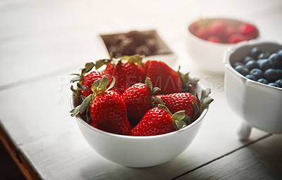 Buy stock photo Bowls, berries and kitchen table for wellness at breakfast with organic choice, nutrition and closeup in home. Fruits, strawberry and raspberry with container, meal prep and healthy diet in morning