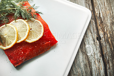 Buy stock photo Shot of a raw piece of meat garnished with slices of lemon