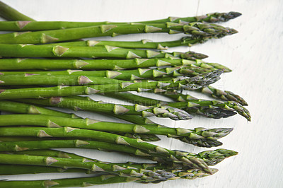 Buy stock photo Asparagus, kitchen and food on table for wellness, lunch or decision with nutrition for health. Organic vegetable, cooking and above for benefit on counter, detox or meal prep for vegan diet in home