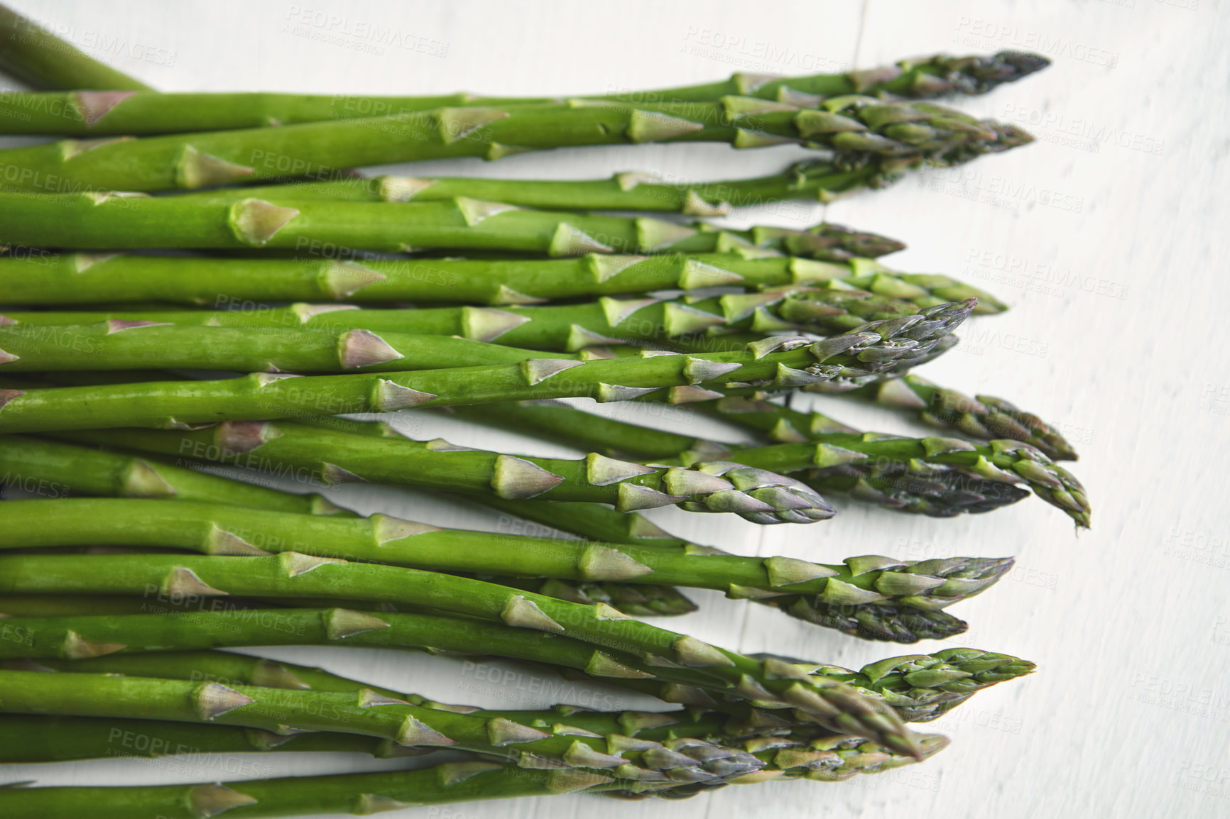 Buy stock photo Asparagus, kitchen and food on table for wellness, lunch or decision with nutrition for health. Organic vegetable, cooking and above for benefit on counter, detox or meal prep for vegan diet in home