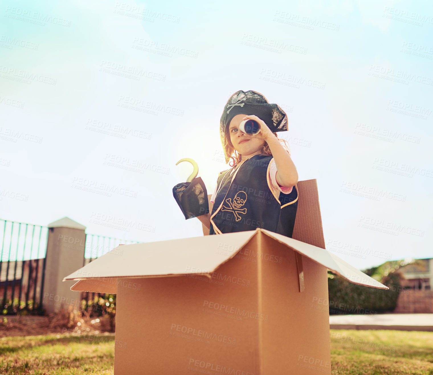 Buy stock photo Pirate, playing and portrait of child in box for imagination, creativity or outdoor role play. Girl, cardboard container and captain with spyglass vision in backyard for pretend, adventure or fantasy