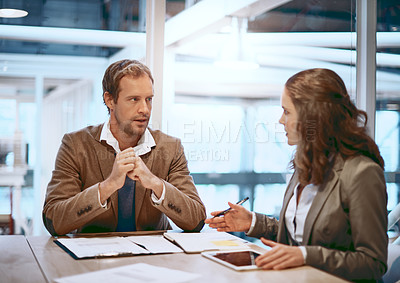 Buy stock photo Cropped shot of two businesspeople working together in the boardroom