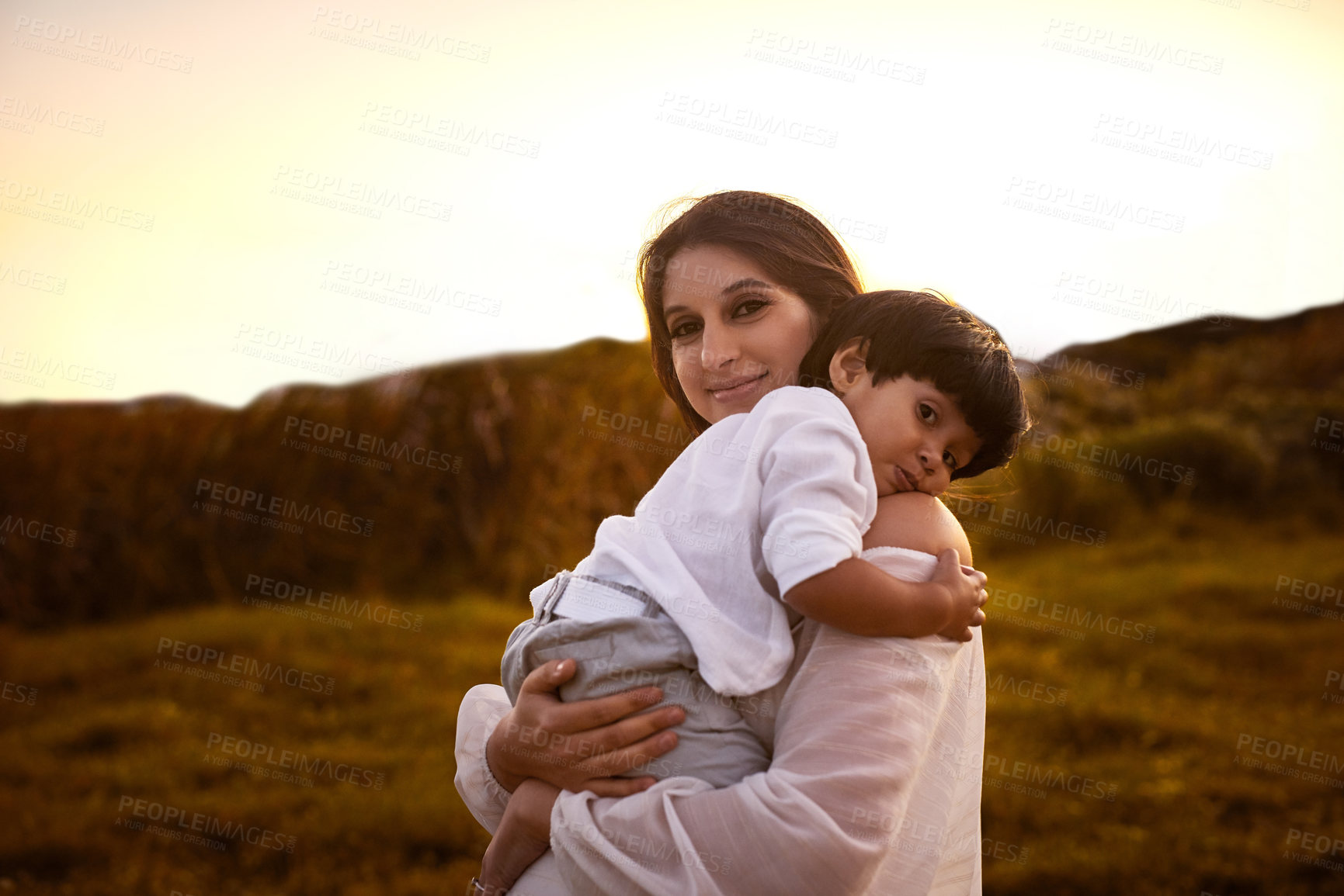 Buy stock photo Shot of a young mother holding her son outdoors