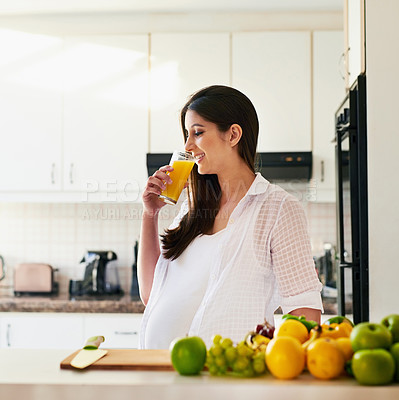 Buy stock photo Shot of young pregnant woman drinking a glass of orange juice at home