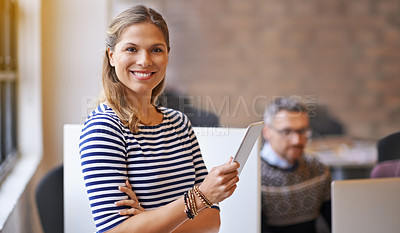 Buy stock photo Shot of a young woman standing in a office with a tablet in her hand and smiling brightly to the camera