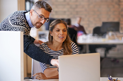 Buy stock photo Shot of a mature man helping out a work colleague on her laptop in the office
