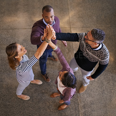 Buy stock photo High angle shot of a group of work colleagues engaging in high fives in a circle in the office