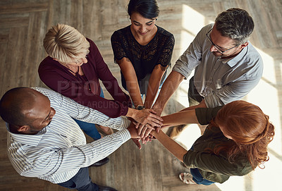 Buy stock photo A group of business professionals putting their hands together in unity, supporting each other and standing as a team top view. Diverse male and female design company employees uniting for a project