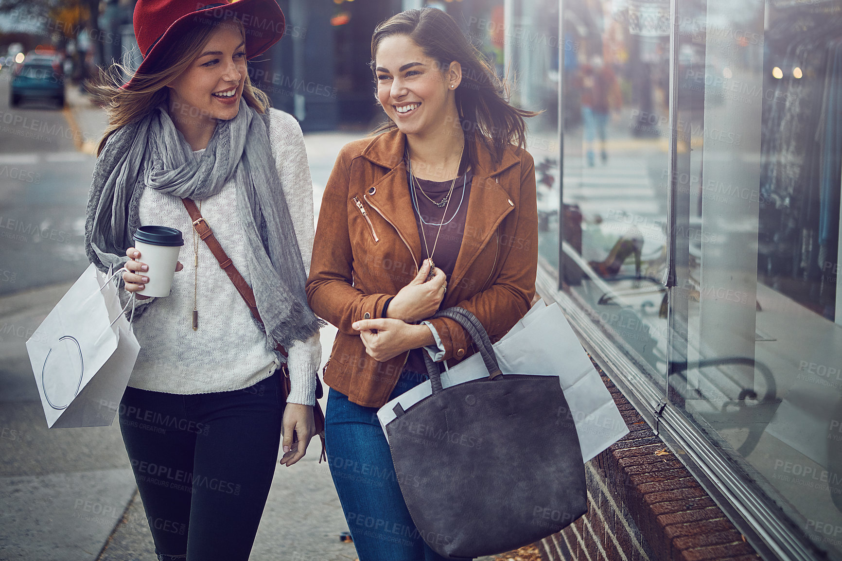 Buy stock photo Cropped shot of two young girlfriends walking around downtown while on a shopping spree