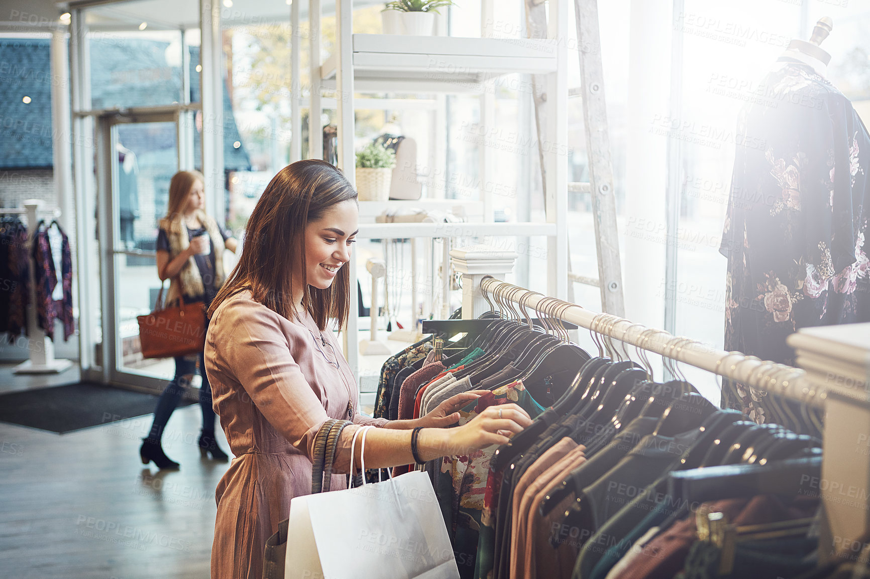 Buy stock photo Shot of a young woman shopping at a clothing store