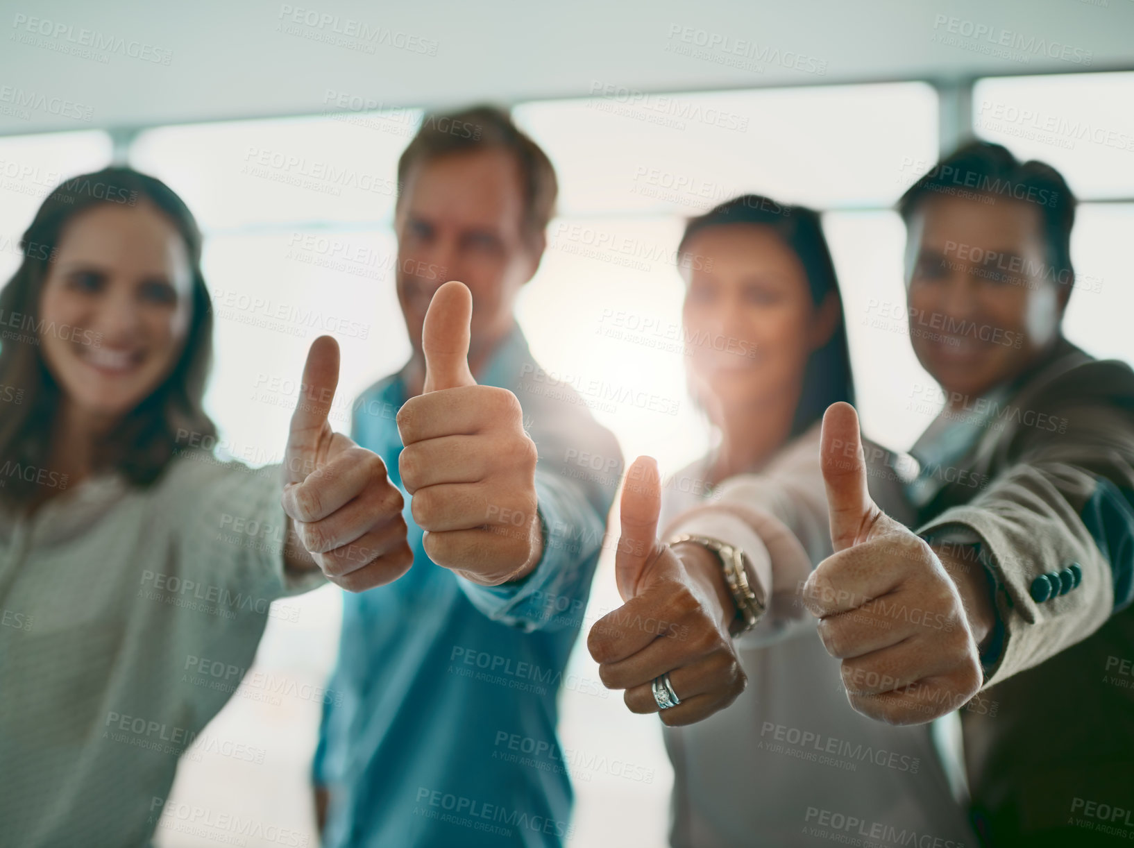 Buy stock photo Cropped shot of a motivated group of businesspeople showing thumbs up and smiling while looking at the camera