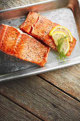 Buy stock photo Shot of a piece of fish garnished with slices of lemon and fresh leaves in a dish