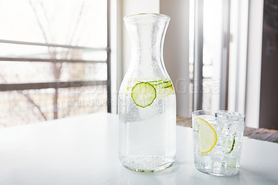 Buy stock photo Shot of a jug and glass of water with slices of lemon and cucumber in