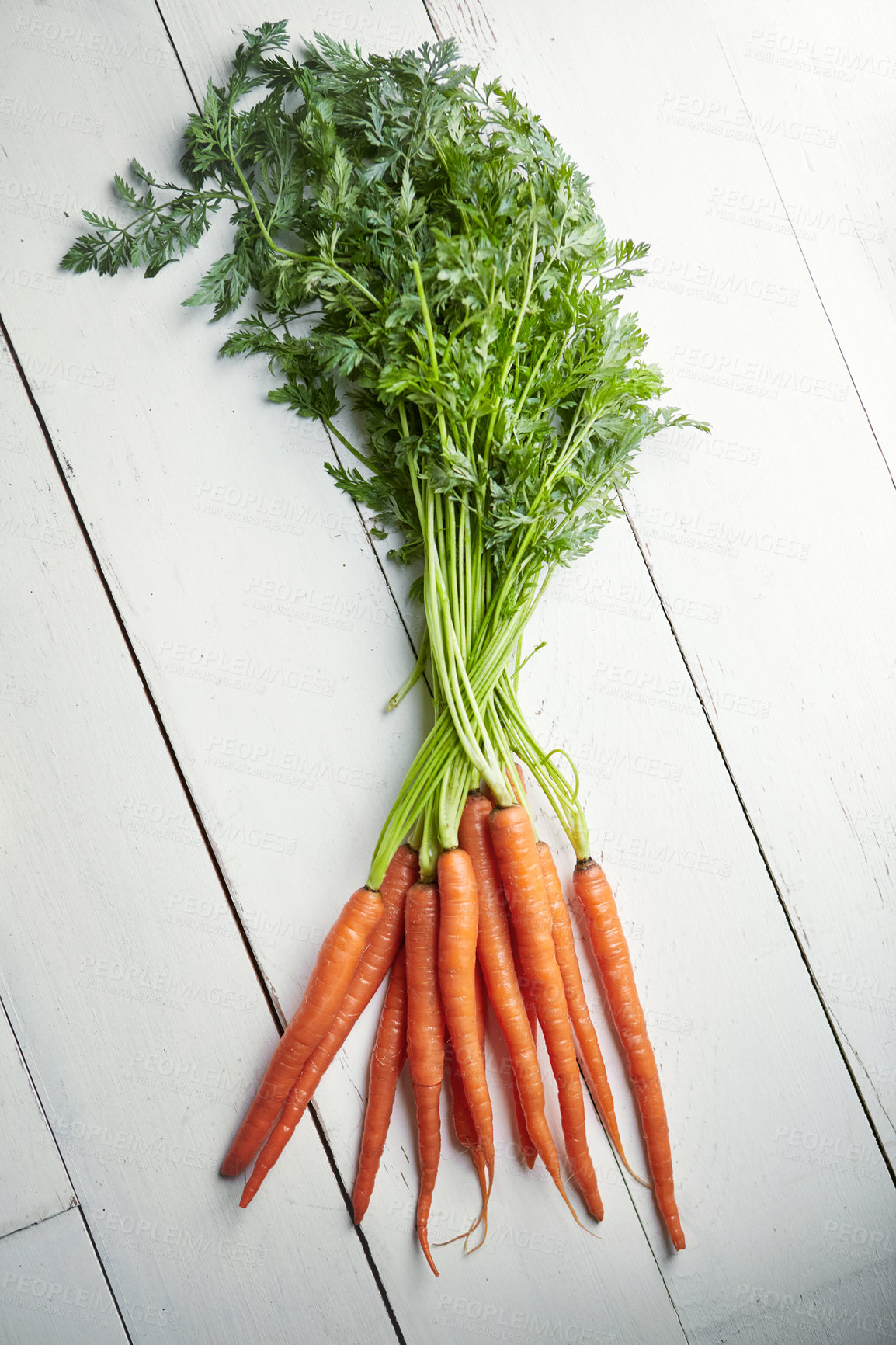 Buy stock photo Shot of a bunch of fresh carrots on a table