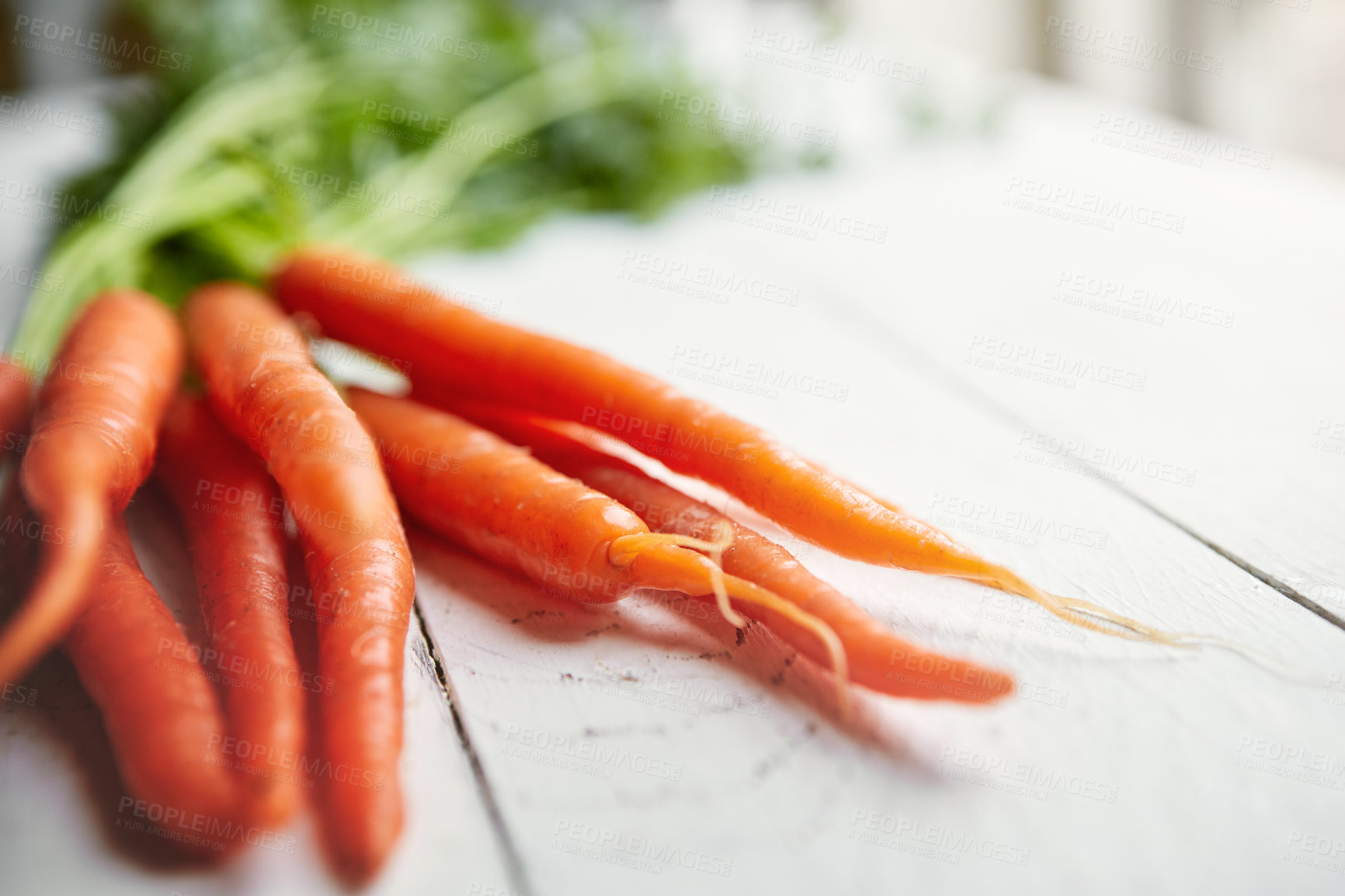 Buy stock photo Shot of a bunch of fresh carrots on a table