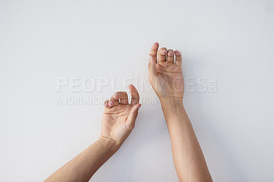 Buy stock photo Cropped shot of a unrecognizable person's hands against a grey background stretching up