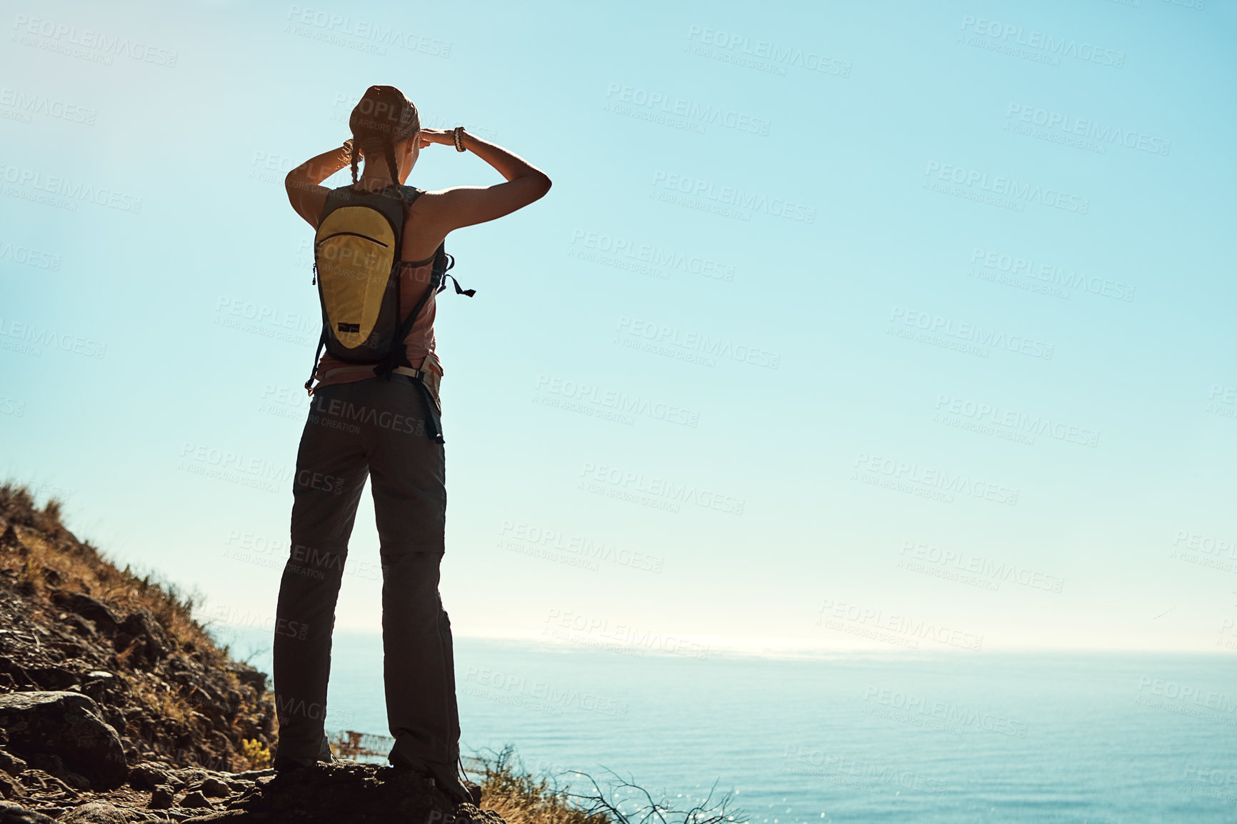 Buy stock photo Rear view shot of a young woman admiring the view from the top of a mountain