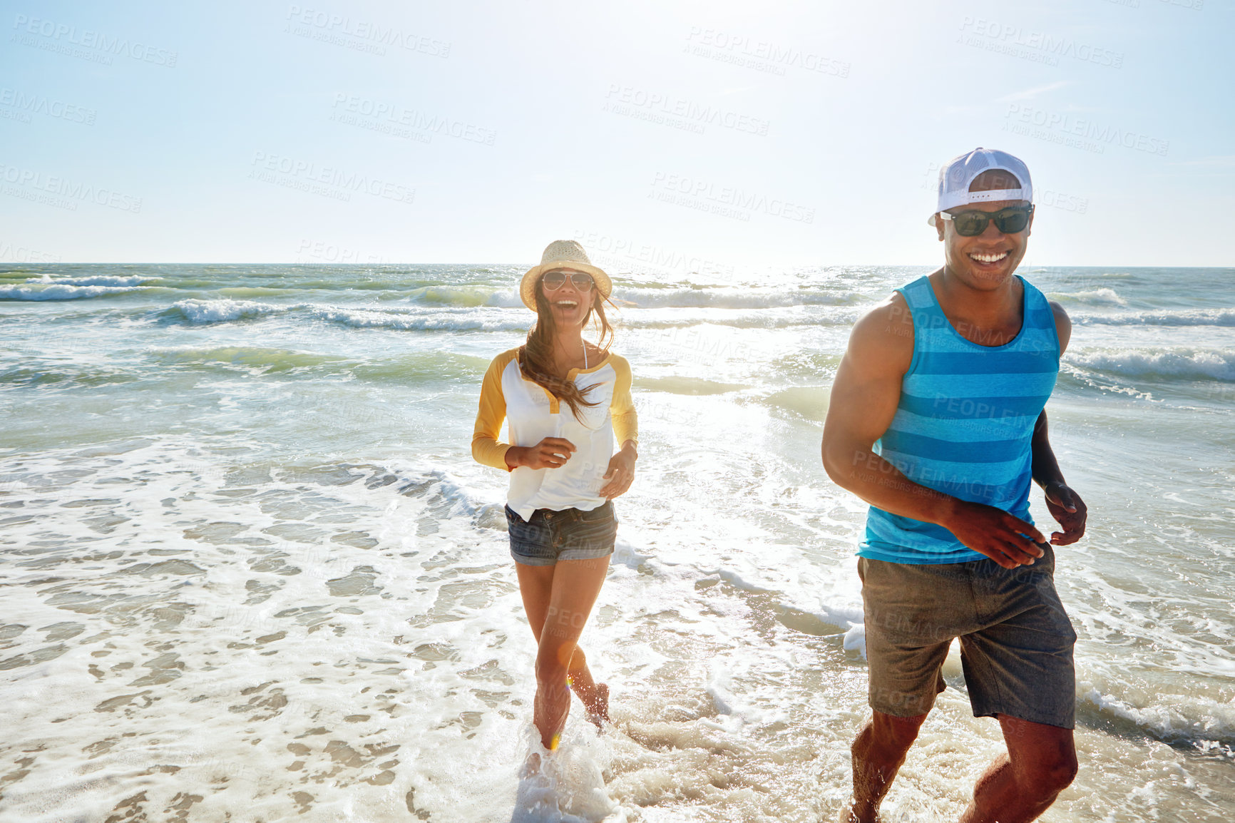 Buy stock photo Sunshine, portrait and couple walking on ocean for adventure, holiday and bonding together. Outdoor, beach and playful with happy people, boyfriend and girlfriend with romance for vacation in Bali