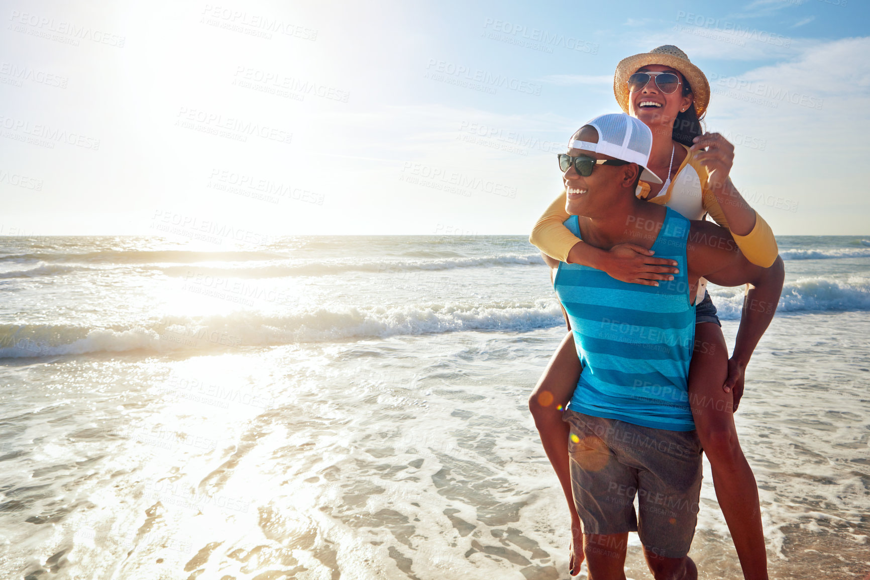 Buy stock photo Black couple, beach and piggyback for holiday, vacation and bonding with romance, fun and adventure. Happy young people walking with sunglasses in Miami for support, travel and love in lens flare