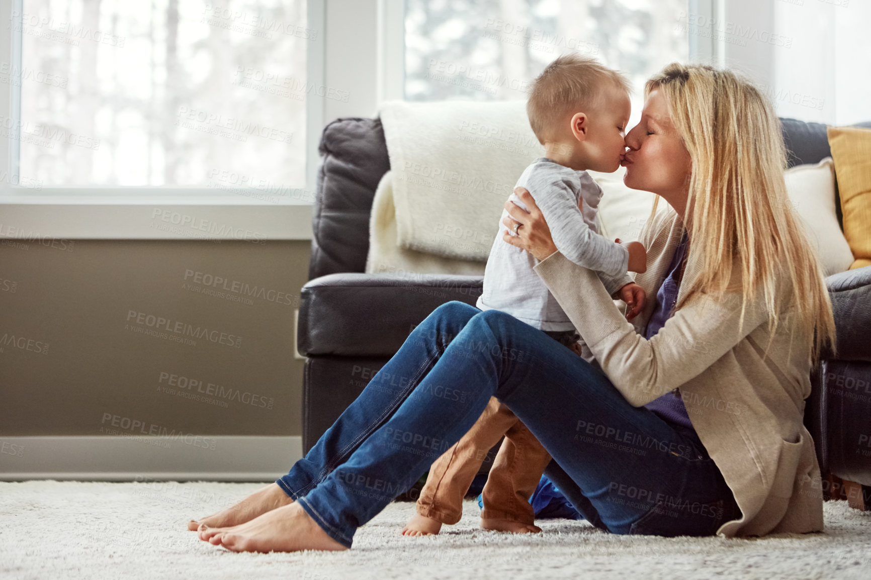 Buy stock photo Lounge, care and kiss of baby by mom, home and bonding with son, embrace and love in apartment. House, mother and toddler in living room, hug and together on floor, happiness and wellness for boy