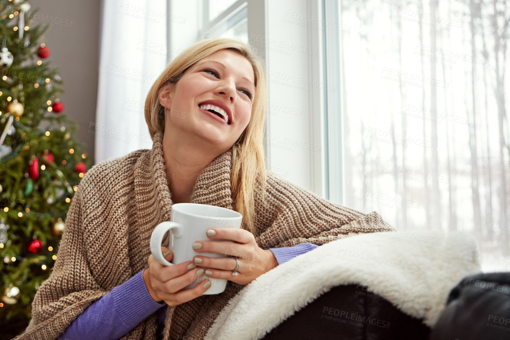 Buy stock photo Shot of a young woman relaxing at home with a cup of coffee