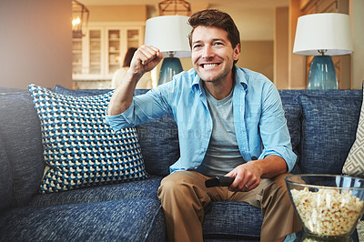 Buy stock photo Shot of a happy man celebrating while watching a sports match on tv