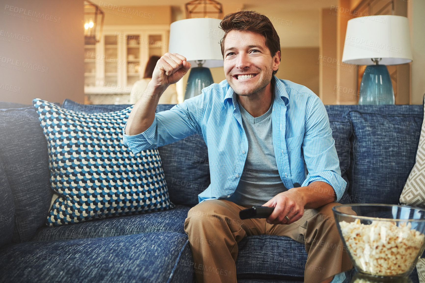 Buy stock photo Excited, popcorn and man on couch with remote for watching tv, streaming football game and celebrate for sports. Guy, sofa and happy for soccer team win in apartment with live television broadcast