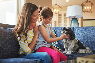 Buy stock photo Shot of an adorable little girl, her mother and their dog spending time together at home