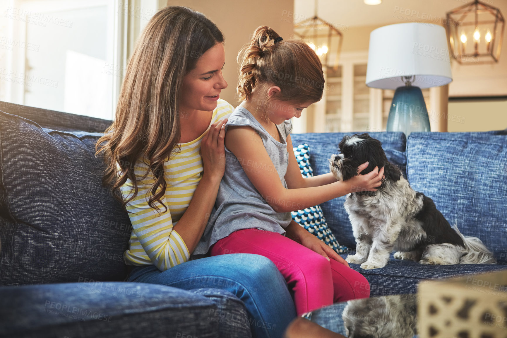 Buy stock photo Mother, girl and dog on couch with smile for relationship trust and support for animal care in home. Happy woman, kid and maltese on apartment sofa for love connection and bond together with scratch