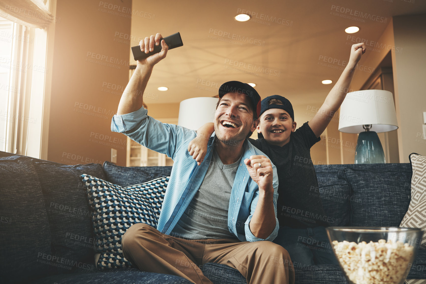 Buy stock photo Popcorn, television and dad with kid in celebration for streaming, subscription and bonding together. Man, son and happy with fist in success at home for sports, network and watching live broadcast