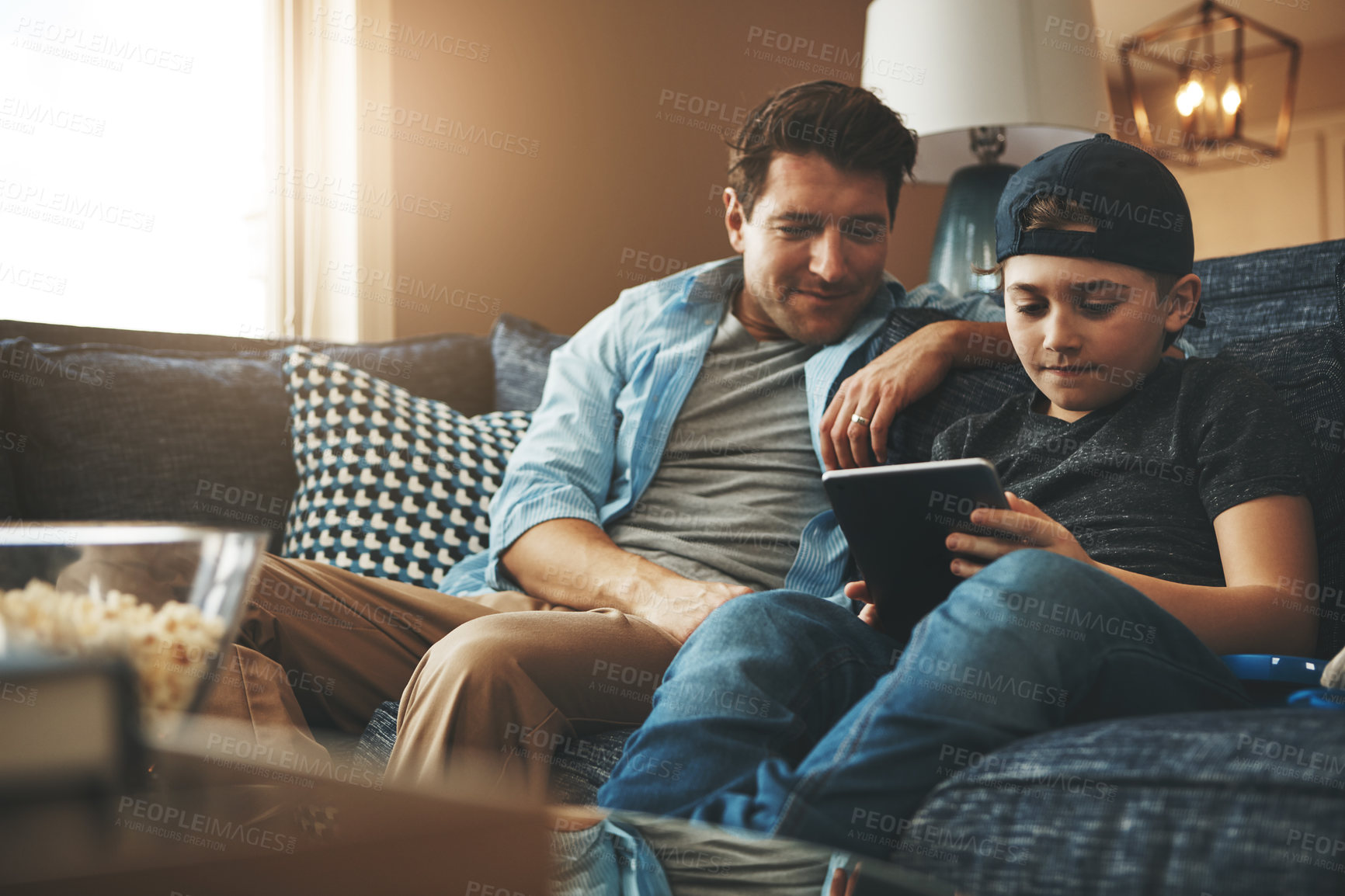 Buy stock photo Tablet, father and boy on sofa with internet for reading ebook, relationship love and streaming animation for fun in home. Child, dad and tech on couch with website for learning language and game app