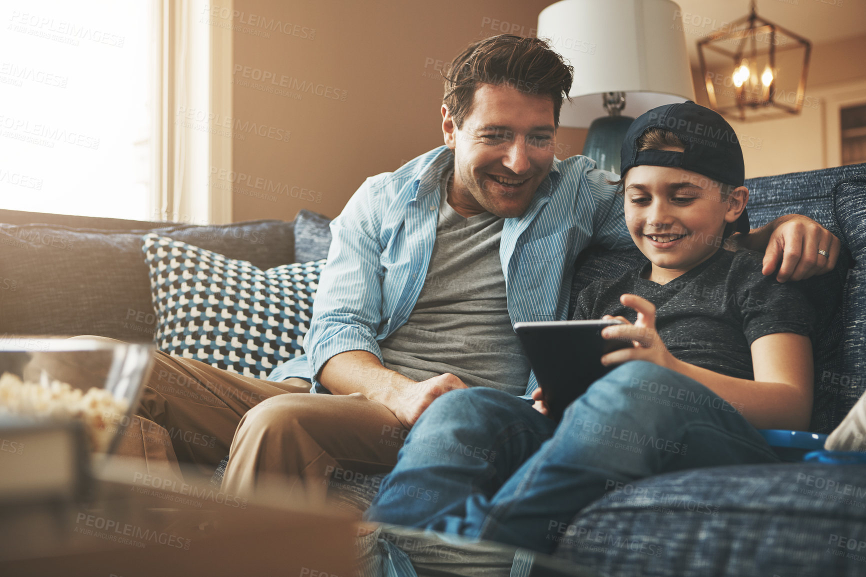 Buy stock photo Dad, child and family on sofa with tablet for online streaming service, movies or funny games on holiday. Happy man on fathers day with son on digital tech for website, support and teaching at home