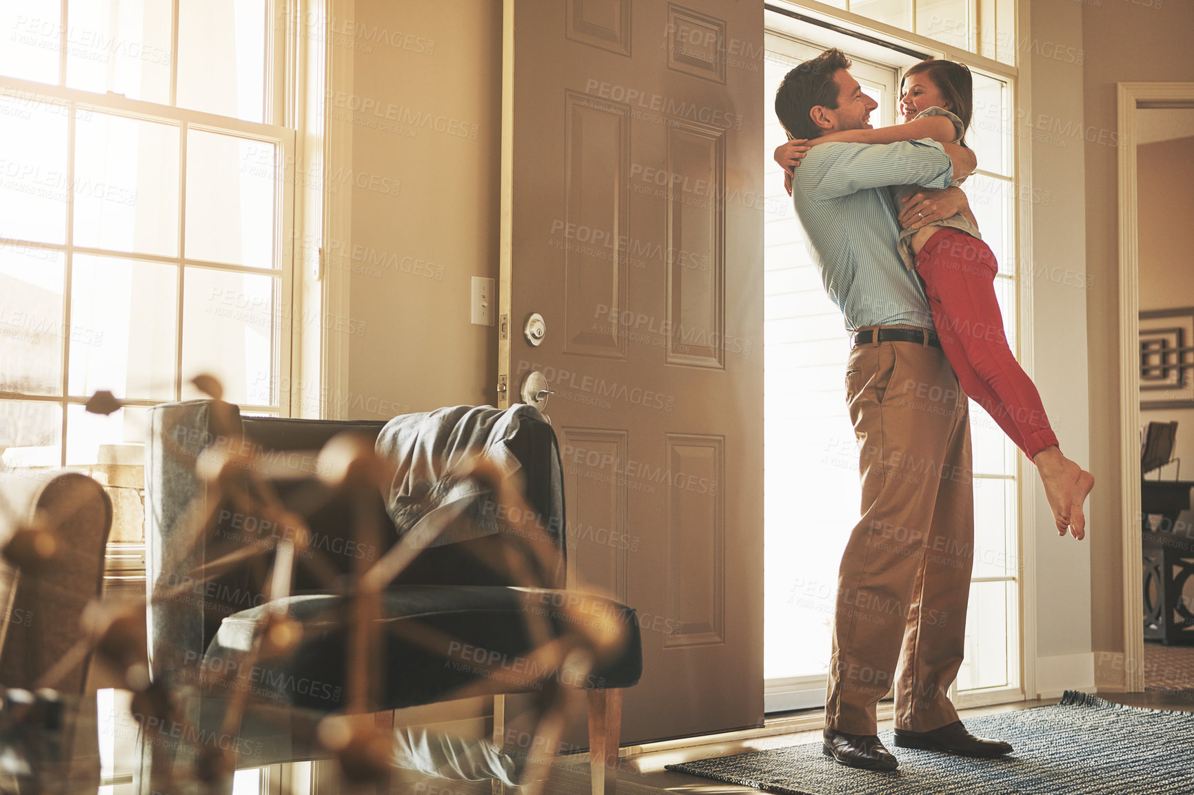 Buy stock photo Shot of a happy father arriving home to a loving welcome from his daughter