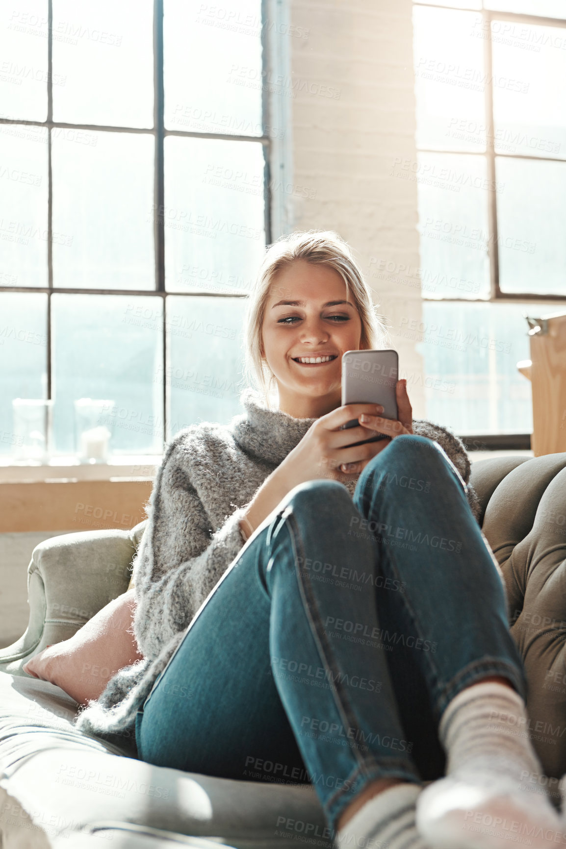 Buy stock photo Phone, happy and woman in home on social media, news and reading email in living room. Smartphone, smile and girl relax on sofa to scroll on app, blog and chat on mobile website on internet in house