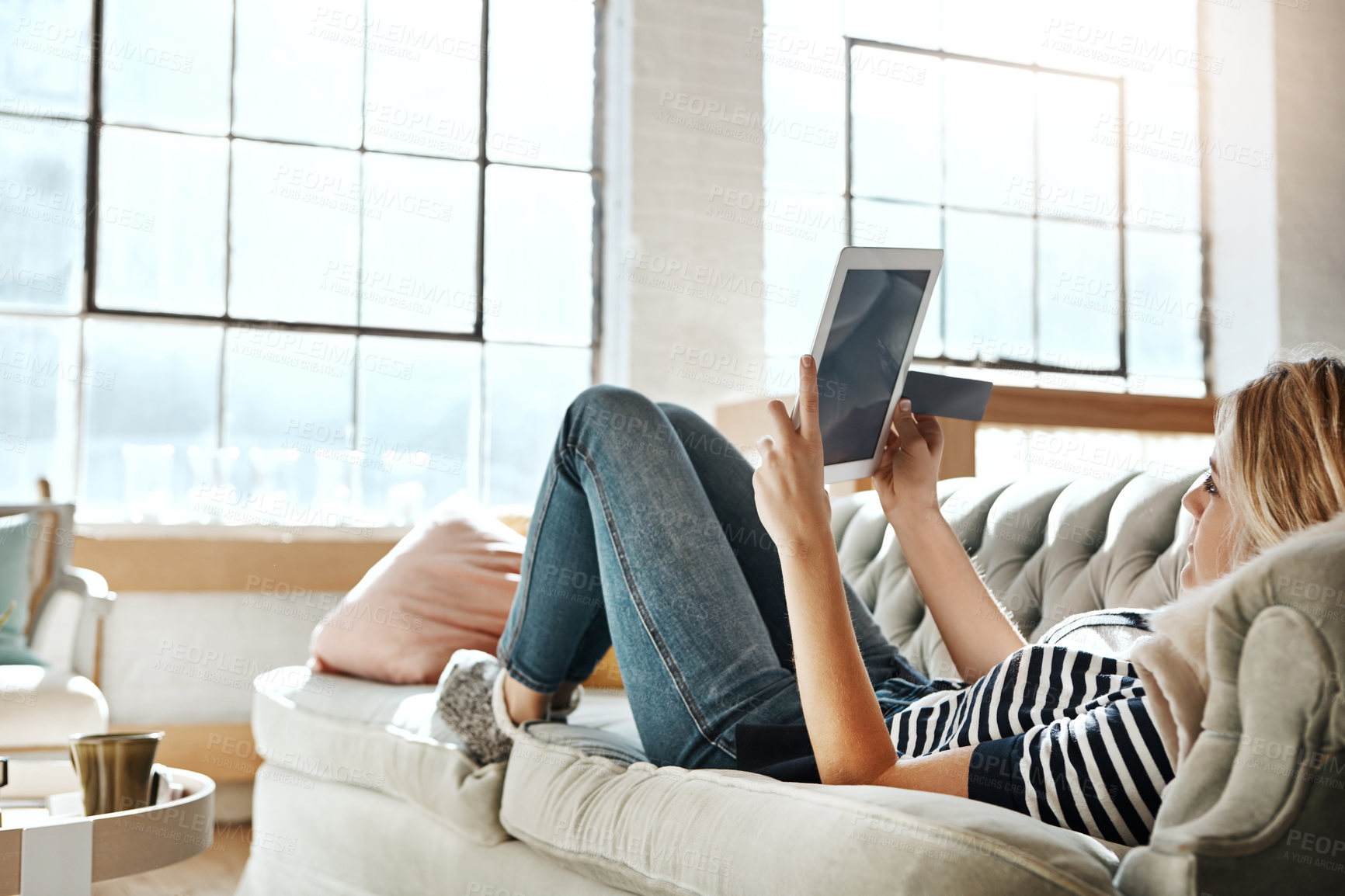 Buy stock photo Woman, tablet and credit card for online shopping on sofa relaxing in the living room for ecommerce at home. Female shopper banking on touchscreen with bank card for purchase, app or sale on couch