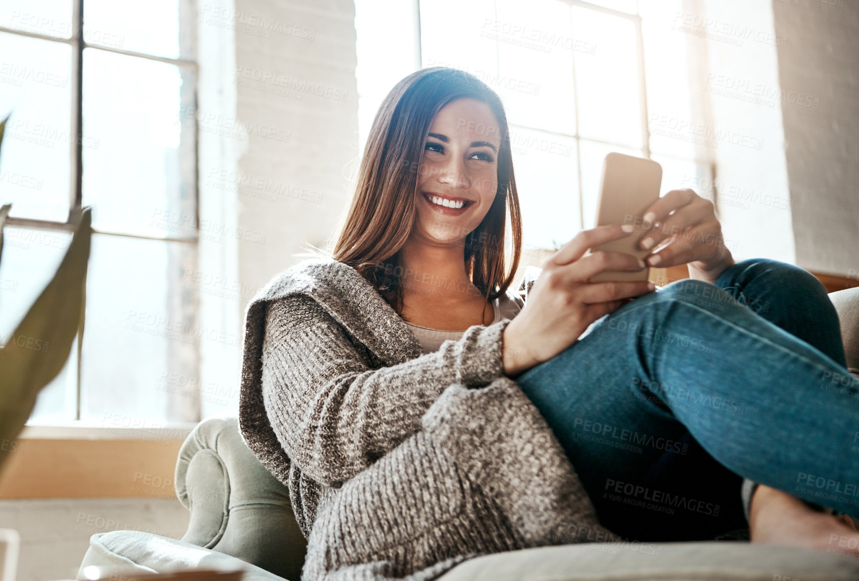 Buy stock photo Relax, happy and woman with phone on sofa at home for social media, connectivity and notification. Smile, person and tech with internet in living room for network, communication and online dating app