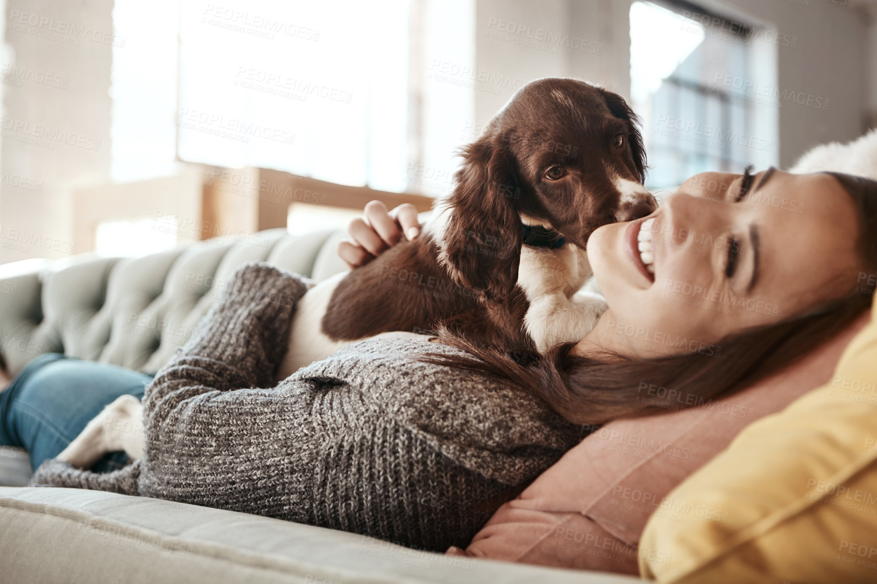 Buy stock photo Smile, relaxing and woman with dog on sofa bonding with pet in living room at apartment. Happy, animal and female person cuddle, hug and embrace puppy with love and care on couch in lounge at home.