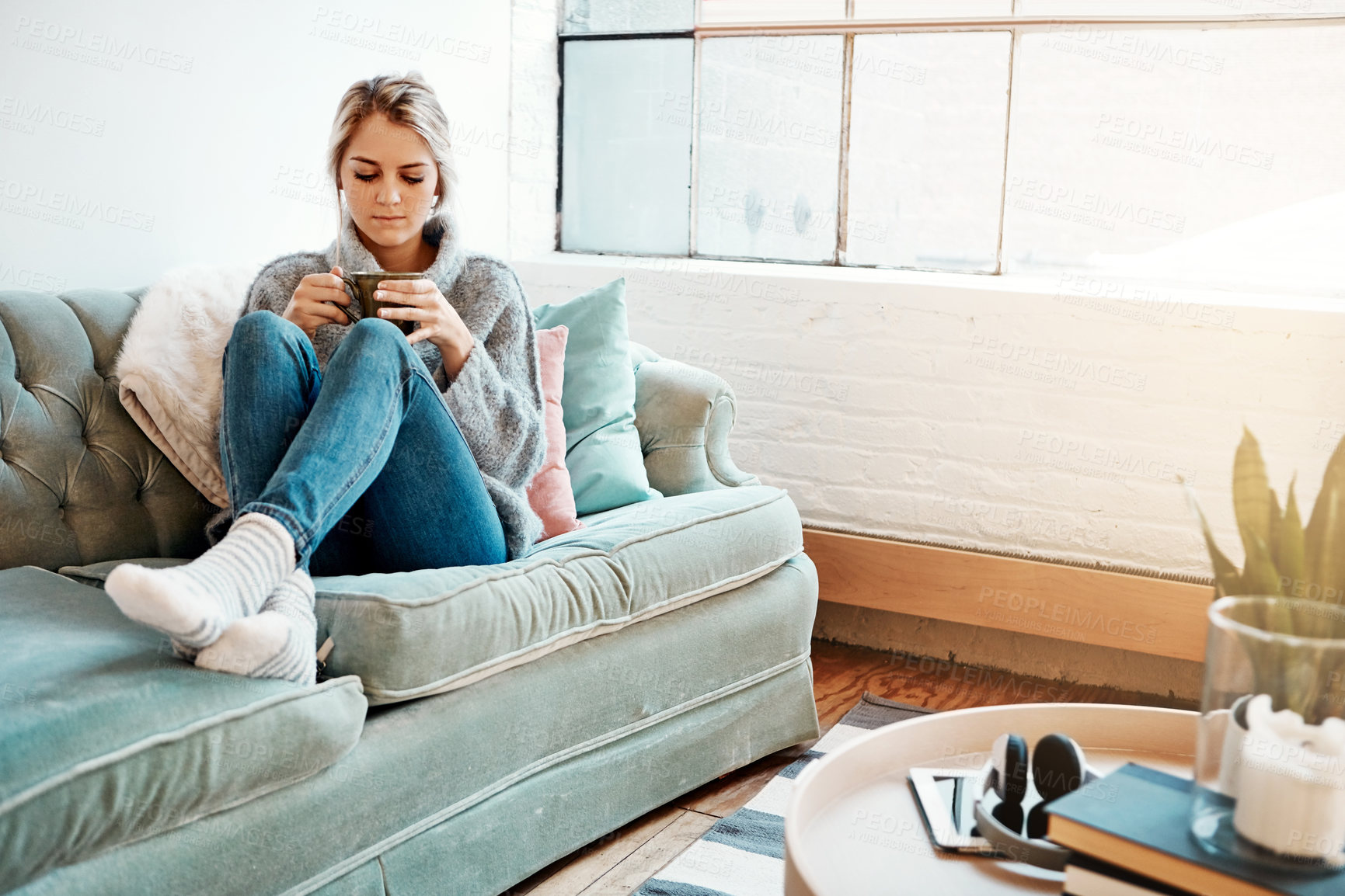 Buy stock photo Young woman, coffee and home on sofa for relax in winter, enjoyment or break from university. Female student, living room and couch with espresso for pause from college, latte in living room