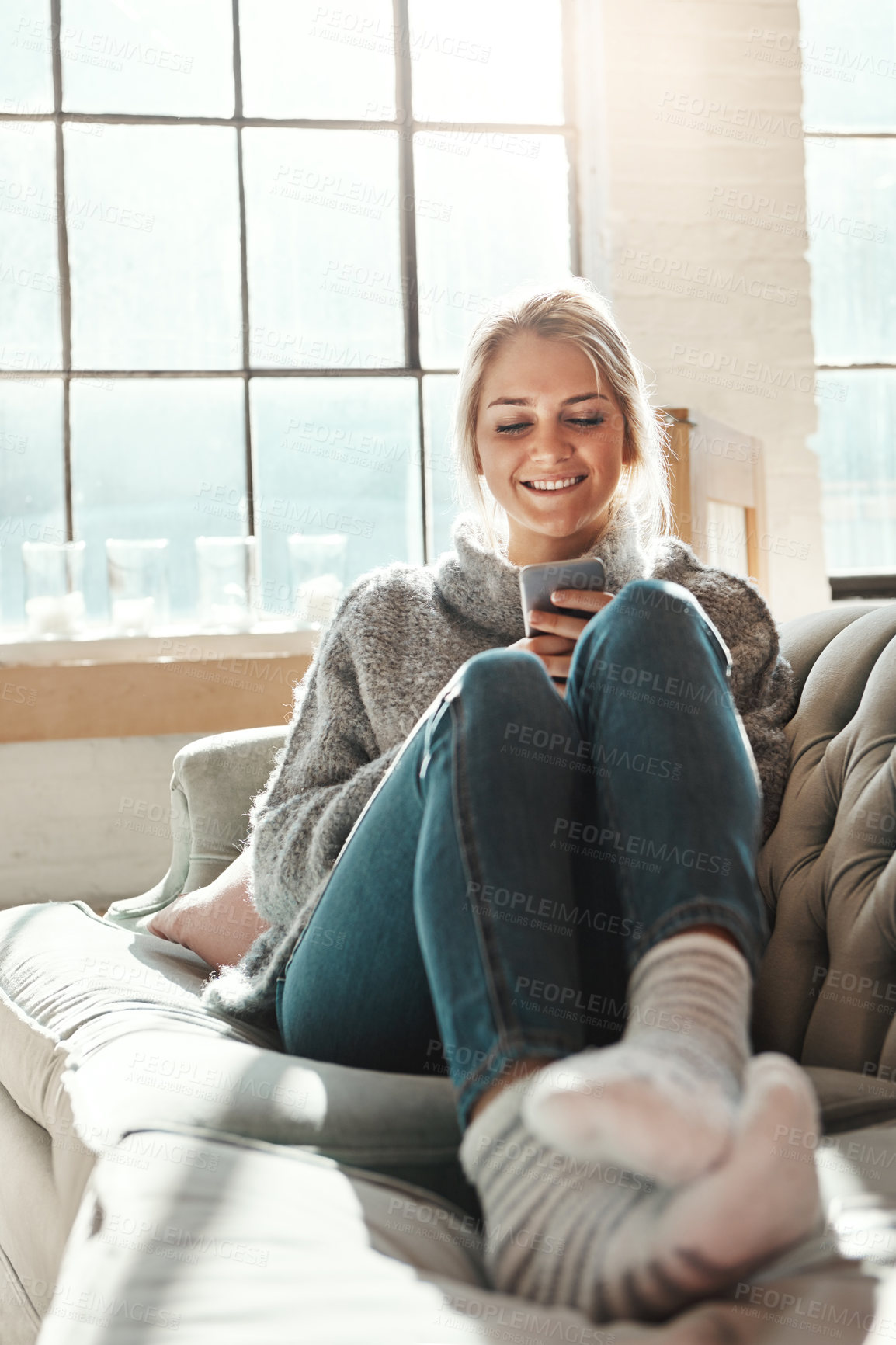 Buy stock photo Phone, smile and woman in home on social media, news and reading email in living room. Smartphone, relax and happy girl on sofa to scroll on app, blog and chat on mobile website on internet in house