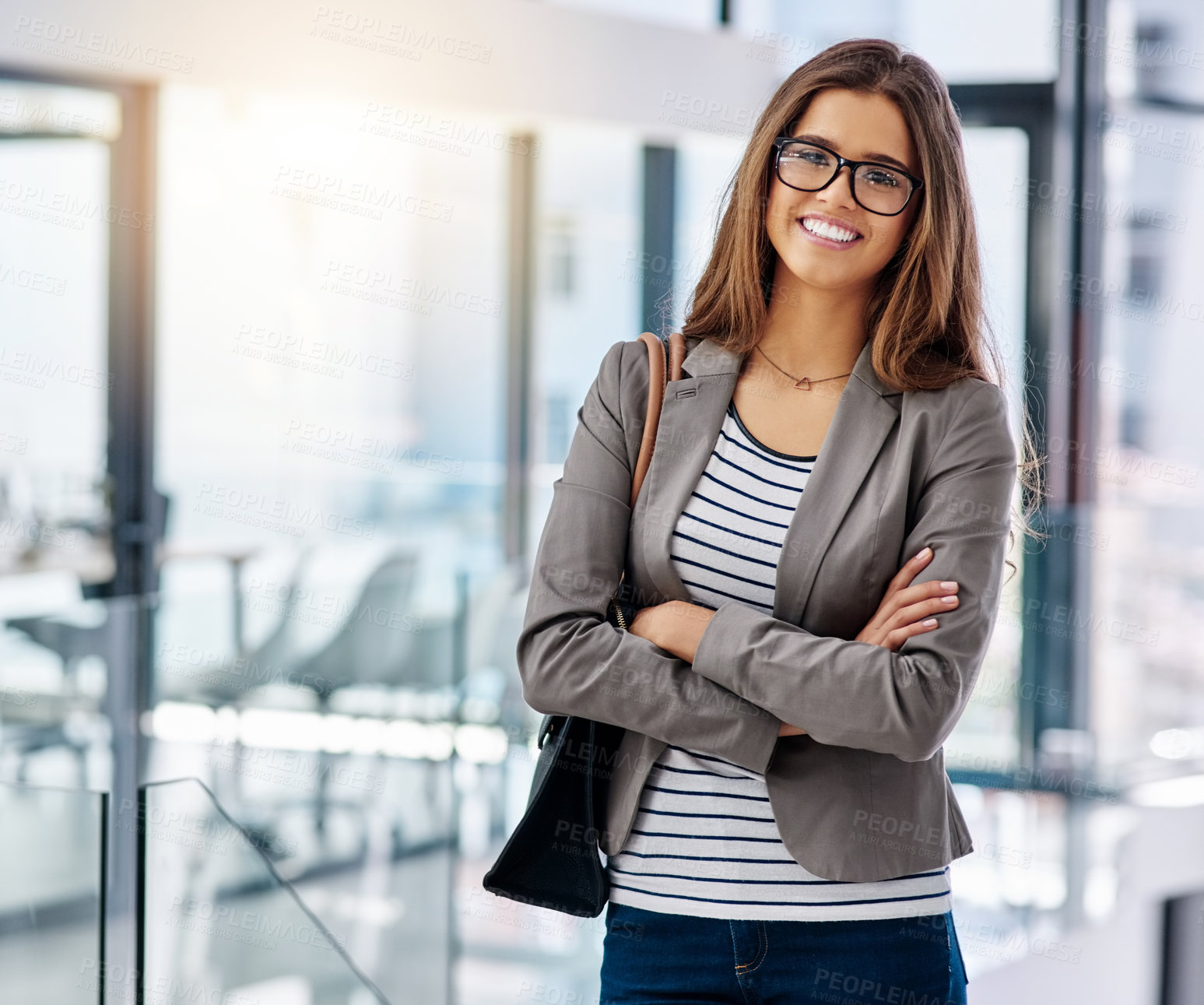 Buy stock photo Cropped portrait of an attractive young female designer standing with her arms crossed in the office