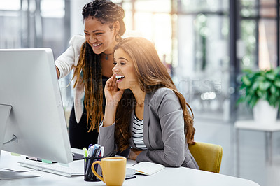 Buy stock photo Cropped shot of two attractive young businesswomen working at a desk in their office