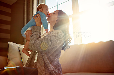 Buy stock photo Mother, baby and kiss on cheek in living room on sofa with love for relationship with new born, care. Embrace, light and sunshine for relax on couch with playing, joy and happiness for wellness.