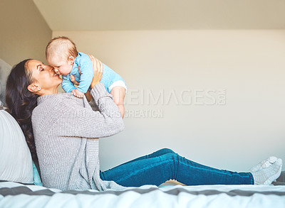 Buy stock photo Shot of a young woman bonding with her baby boy on the bed at home