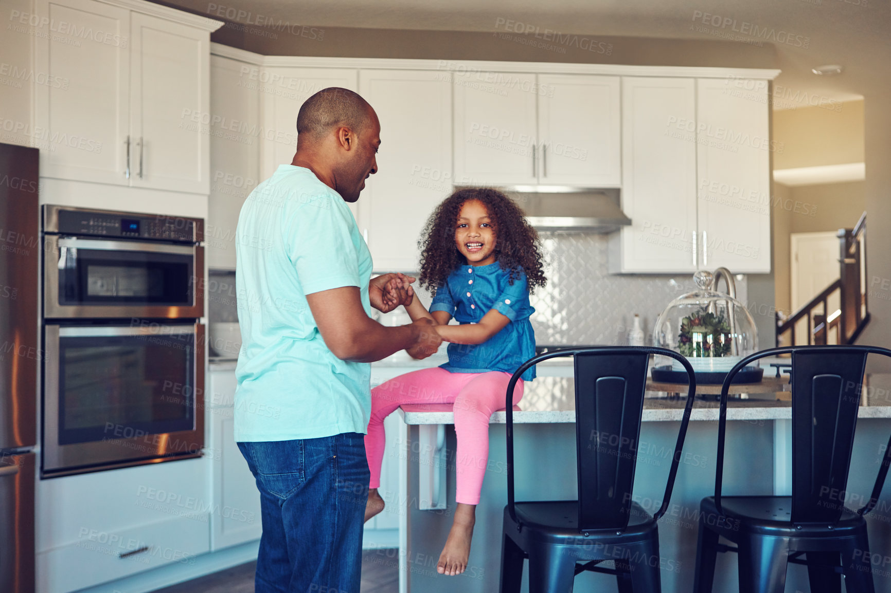 Buy stock photo Shot of a happy little girl and her father bonding in the kitchen at home