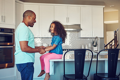 Buy stock photo Shot of a happy little girl and her father bonding in the kitchen at home