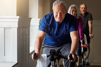 Buy stock photo Shot of a group of seniors having a spinning class at the gym