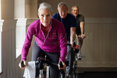Buy stock photo Shot of a group of people having a spinning class at the gym