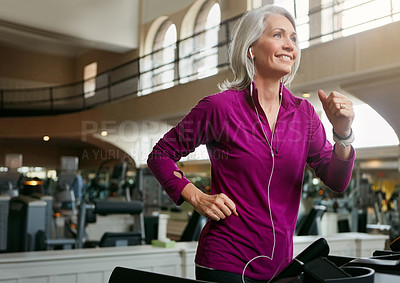 Buy stock photo Shot of a mature woman exercising on a treadmill at the gym
